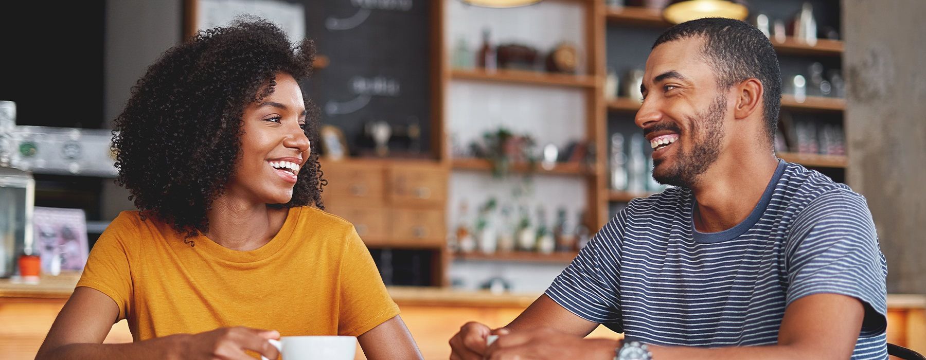 Woman and man at a coffee shop sitting at a table talking