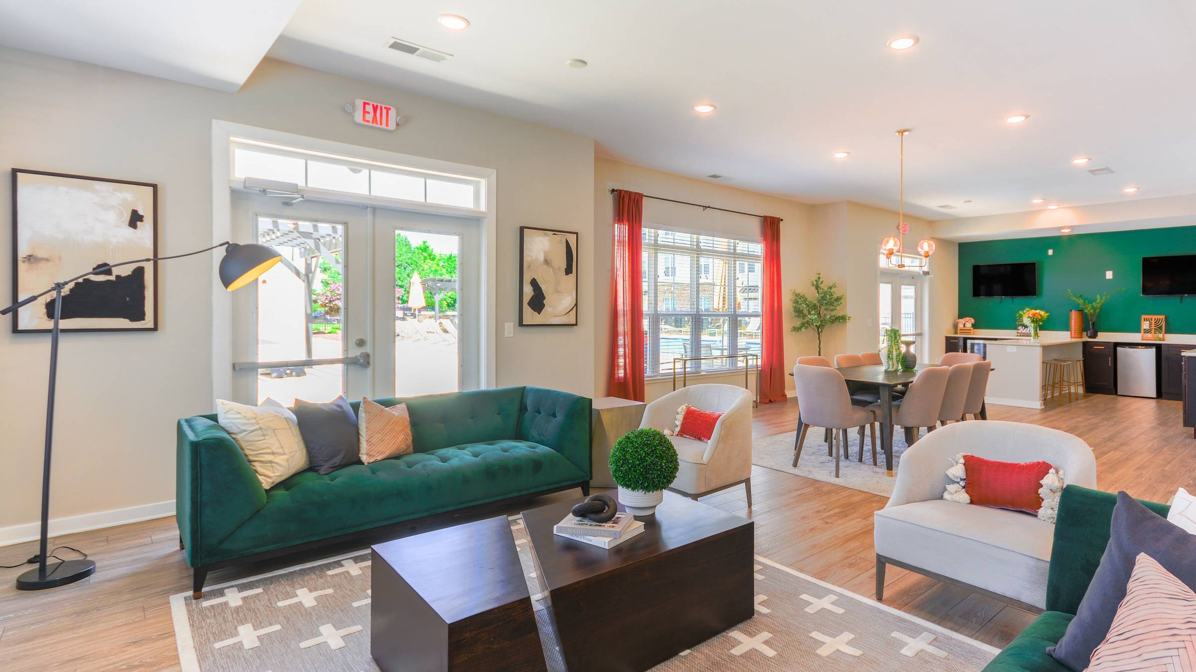 Hawthorne at St. Marks modern and vibrant resident clubroom, featuring a green velvet sofa and stylish decor.