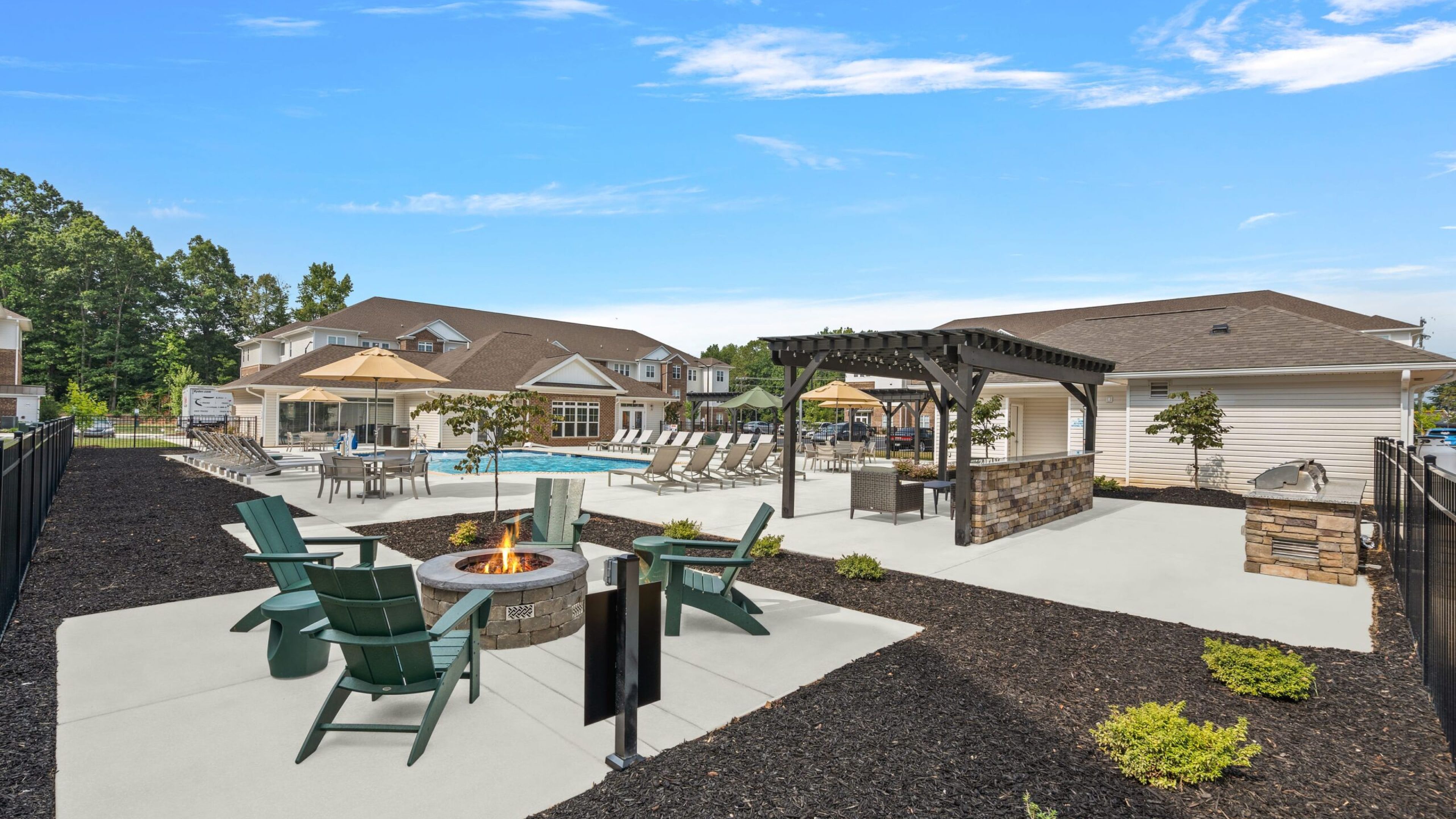 Hawthorne at St. Marks outdoor firepit looking over pool and grill area.