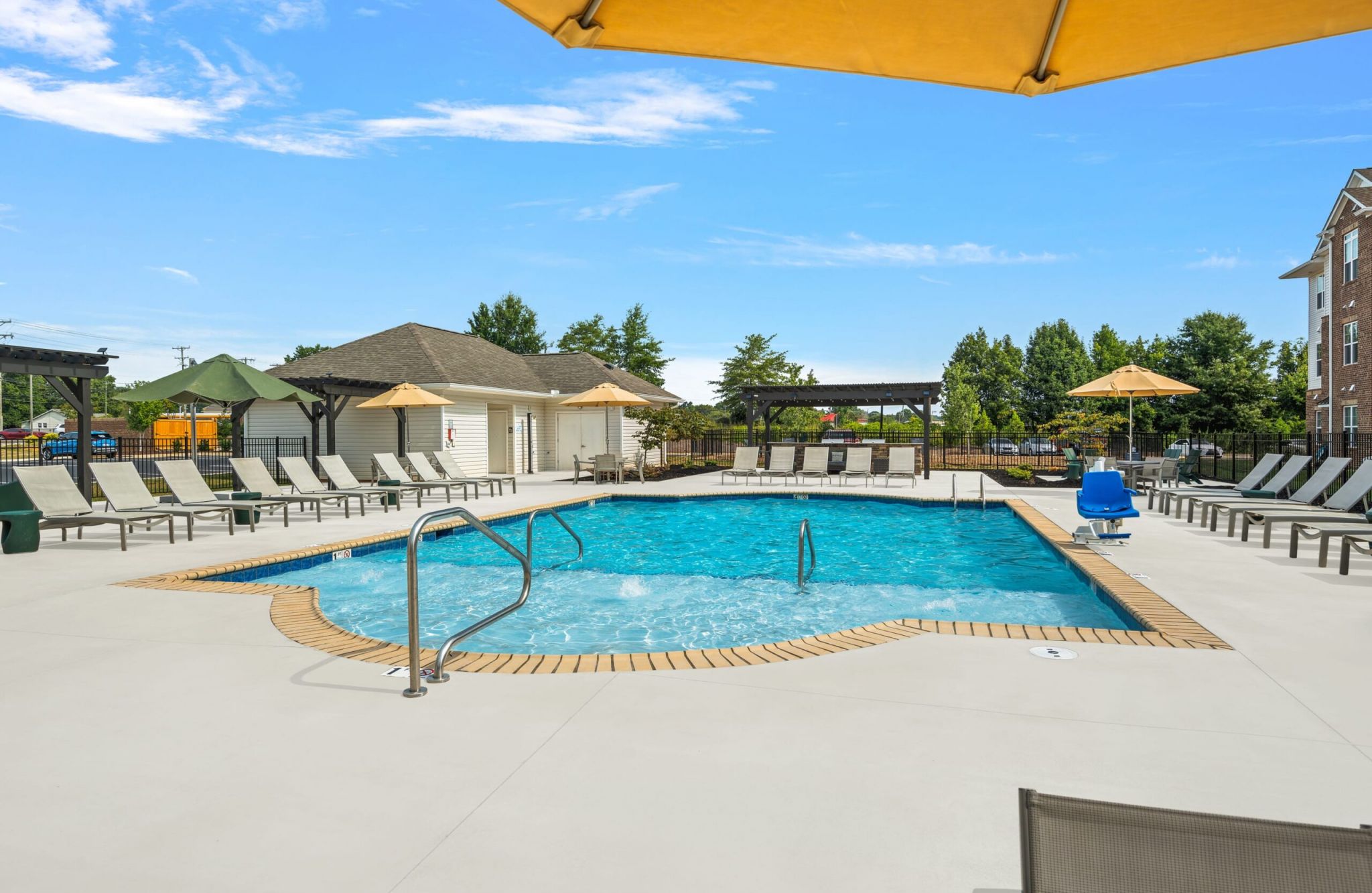 Hawthorne at St. Marks swimming pool with lounge chairs in the shallow water area and surrounding lounge seating and a cabana