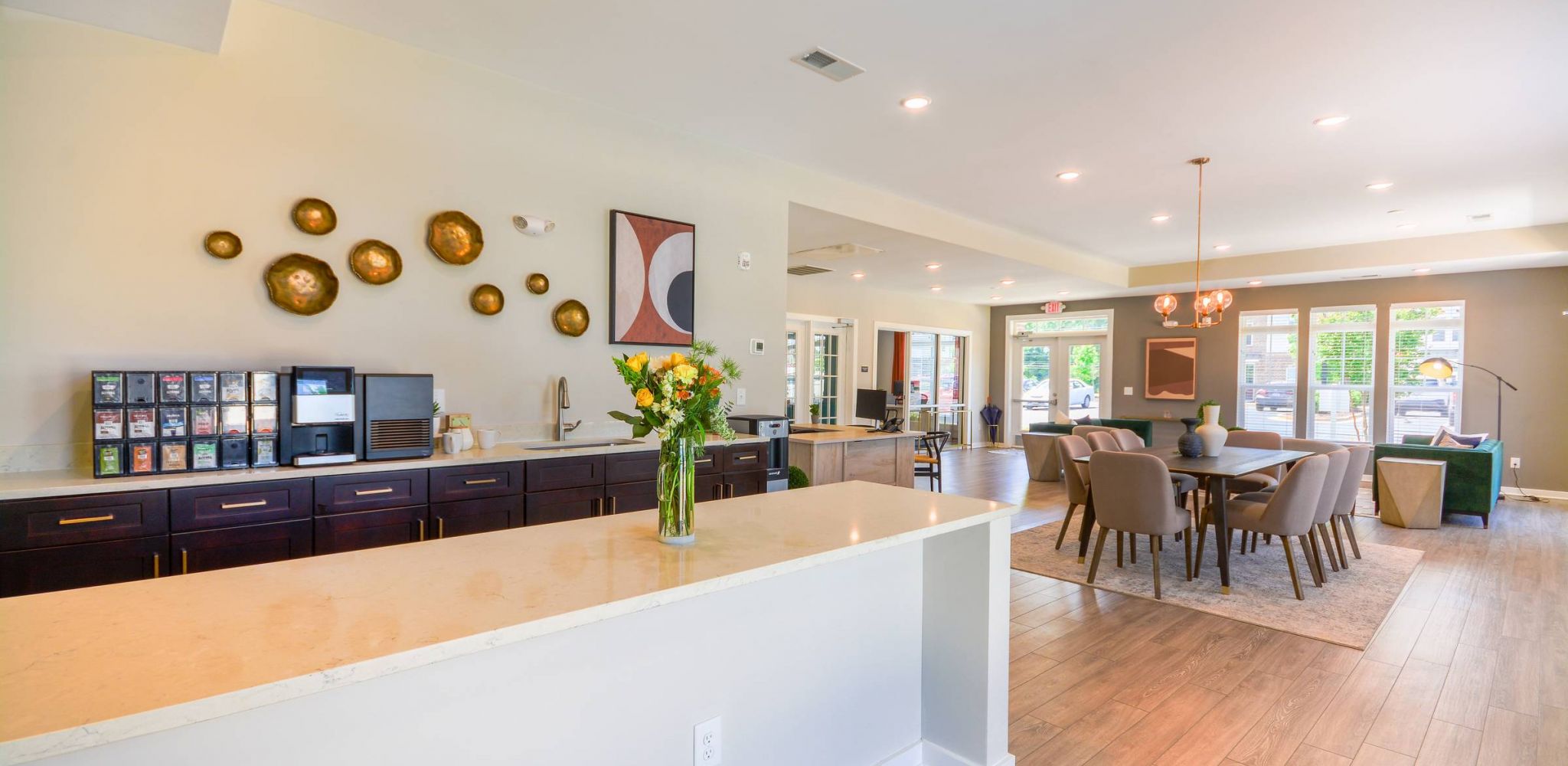 Hawthorne at St. Marks spacious communal dining and kitchen area, highlighted by a central island with a coffee bar and contemporary lighting.